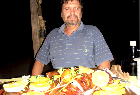 Proprietário do Cruzeiro do Pescador, interagindo com o prato à sua frente, faz cara de &quot;Leitão à Bairrada&quot;.