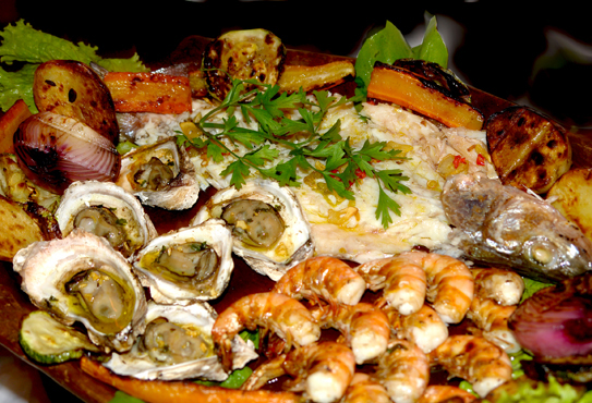 Seleção do Mar. Peixe, polvo, lula, camarões, ostras e lagostas grelhados separadamente no carvão e montados em uma só travessa.